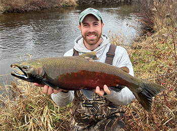Fisheries biologist Sam Peterson with a coho salmon collected from the Brule River.